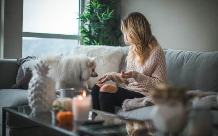 Jeune femme et son chien dans le salon