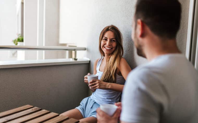 Couple souriant sur leur balcon