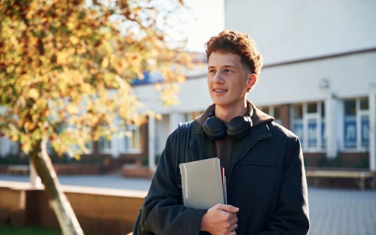 Étudiant à l'extérieur du bâtiment scolaire