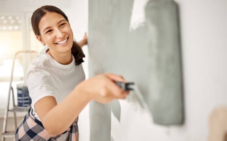 Jeune femme qui peint un mur